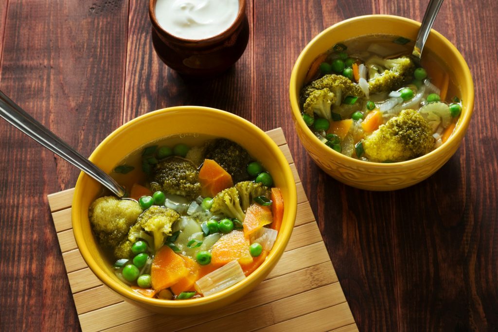  Vegetable Soup - two bowls of soup with peas, carrots and broccoli